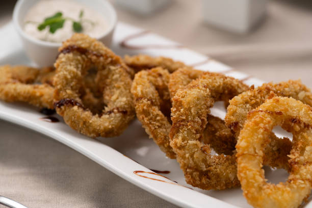 istock Deep fried calamari rings with sauce bowl serving on white plate in restaurant. 2095851903