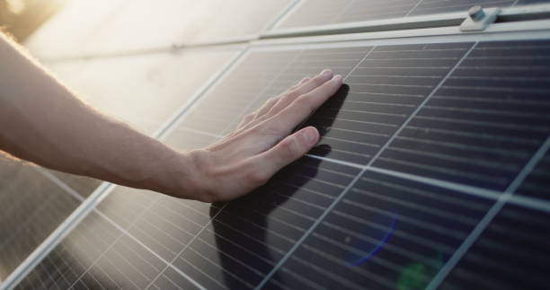 istock Men's hand strokes the surface of solar panels 2095867335