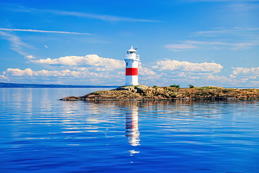 Lighthouse on a skerry with reflections in the water