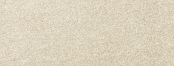 Texture of light beige color background from felt textile material, macro. Structure of vintage ivory fabric cloth, narrow backdrop.