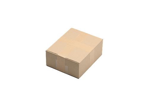 One isolated small courier parcel covered with paper tape lies on a white background