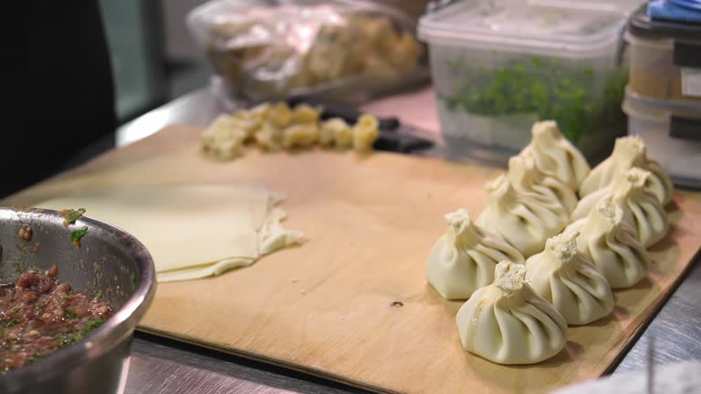 Close-up of female chef's hands sculpting khinkali. Process of making khinkali