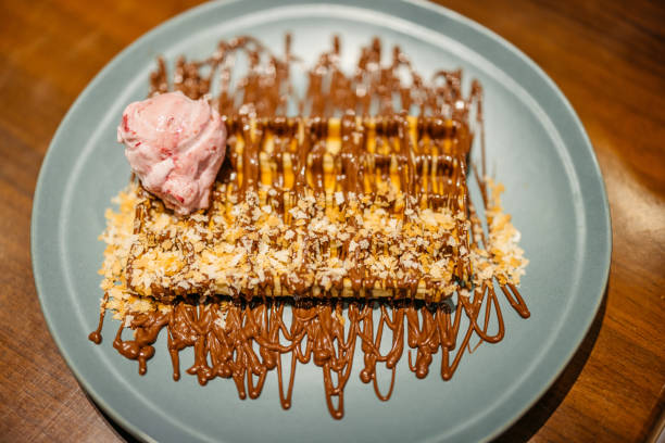 Belgian waffle with ice cream on a table in a pub. Close-up.
