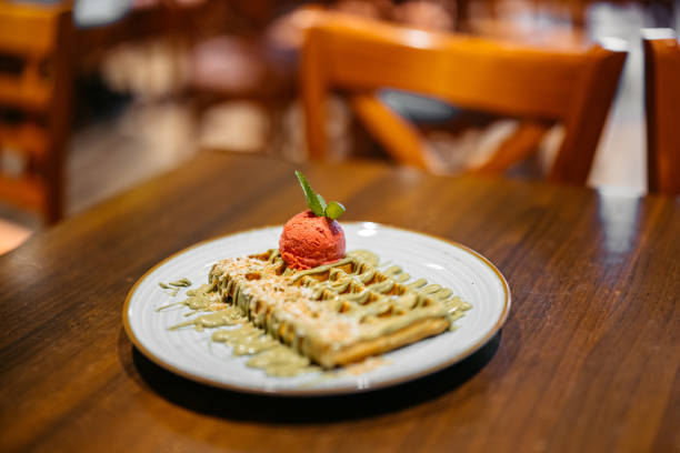 Belgian waffle with ice cream on a table in a pub. Close-up.