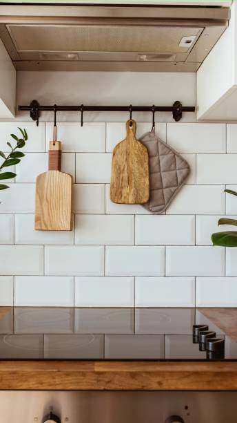 istock Kitchen brass utensils, chef accessories. Hanging kitchen with white tiles wall and wood tabletop.Green plant on kitchen background 2095933456