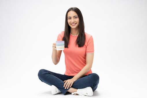 Full length body size photo of young girl sitting on floor wearing jeans denim pink t-shirt footwear isolated over white background