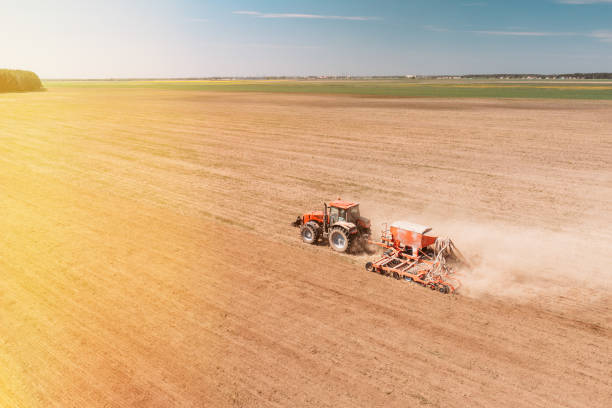 istock Elevated View Tractor With Seed Drill Machine Sowing Seeds For Crops In Spring Season. Beginning Of Agricultural Spring Season. Countryside Rural Field Landscape. Sunlight sunbeam sunshine 2095945928