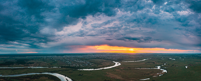 Sunset above river. evenig Panorama Aerial View Green forest And River Landscape. Top View Of Beautiful Nature From High Attitude In Summer Season. Bird's Eye View.