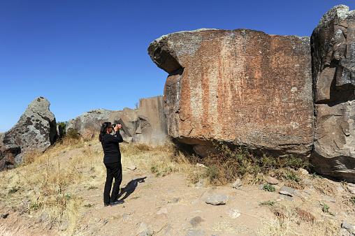 Hittite Monument - Female photographer investigating the Agili Luwi hieroglyphic inscription