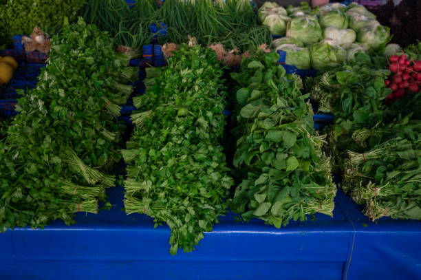Fresh greenery sale in the traditional farm Turkish market, a counter filled with fresh fruits