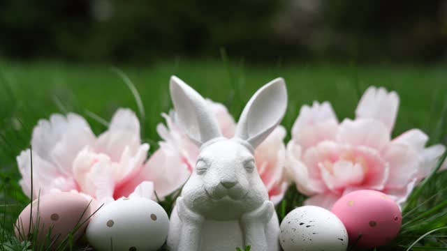 Easter background with bunny, eggs and flowers on green nature background