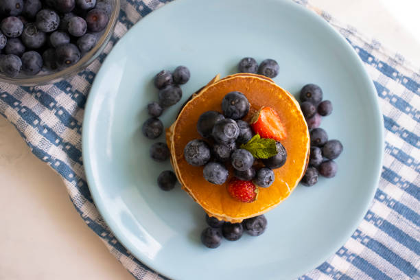 pancakes with strawberries and blueberries on the table