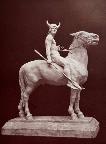 istock Statue: Germanic warrior with lance and horned helmet sitting naked on a horse 2095975147