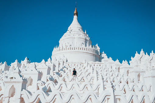 Tourists visit the white Hsinbyume Pagoda during sunset in Myanmar.