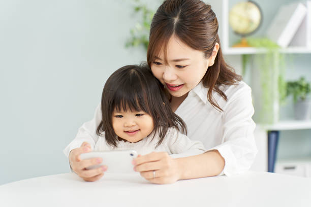 istock Girl looking at smartphone with mom 2095989276