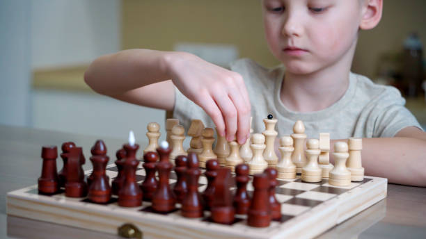 istock Cute little boy playing wooden chess at home. 2096007097