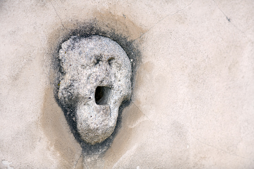 Anthropomorphic face stone in wall