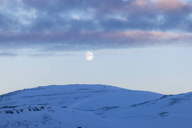 A December full moon in Kootenay National Park in British Columbia, Canada, at dawn.