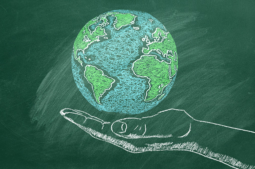 The Globe in a man's hand. Chalk drawn illustration. Save the World. Peace or global business concept. Earth day concept. Travel concept. Trip around the world.