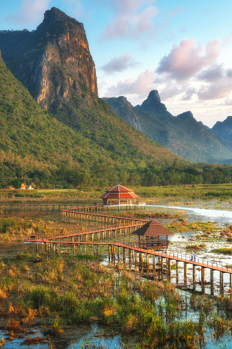 A wooden bridge over a lake with a pavilion on a swamp near the mountain. in Sam Roi Yot National Park Prachuap Khiri Khan, Thailand