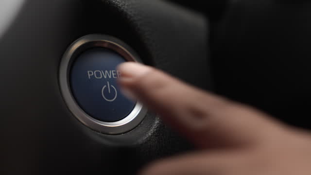 Hand push the car vehicle engine start button to run the engine