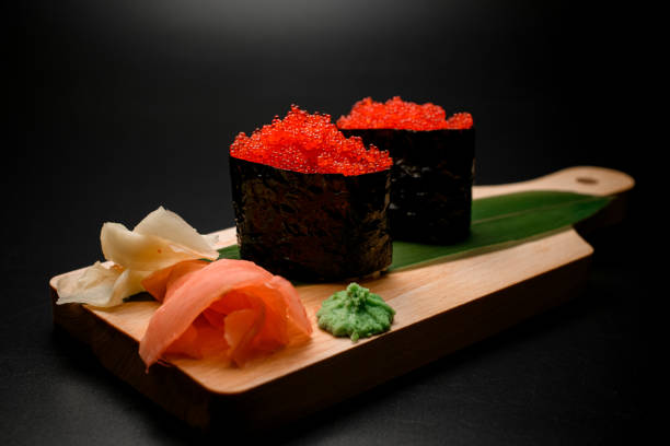 istock Sushi pair on a thick wooden board with red caviar 2096118975