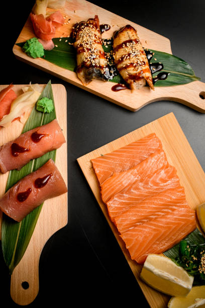 istock Sushi and rolls sets on a wooden boards on a black background 2096127330