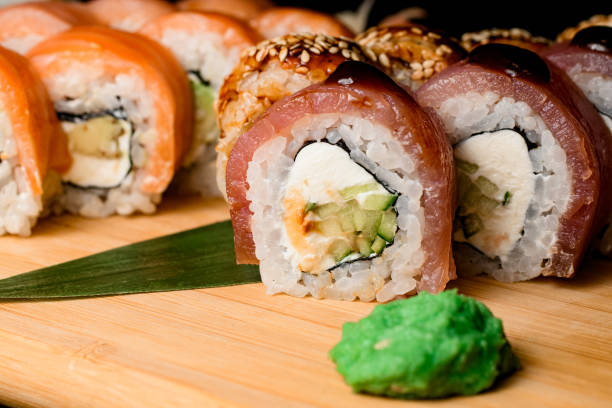 istock Rolls with curd cheese, tuna, salmon, avocado on a brown wooden board 2096137400