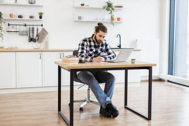 istock Businessman sitting at office desk with digital devices in spacious dining room. 2096141034