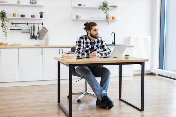 istock Businessman sitting at office desk with digital devices in spacious dining room. 2096141162