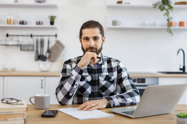 istock Business person posing with pen, documents and portable computer. 2096141176
