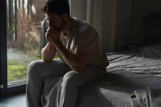 istock Anxious man at home sitting on bed and looking away 2096155586