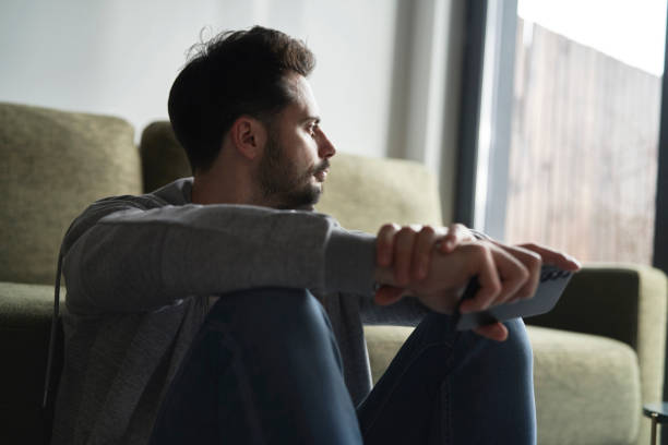 istock Anxious man at home sitting on floor 2096156101