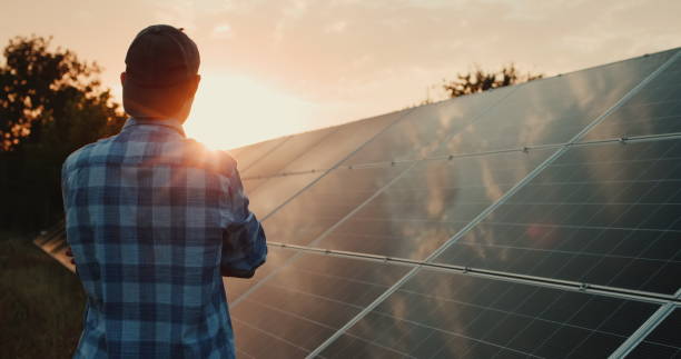 istock Owner looks at solar power plant panels at sunset 2096158208