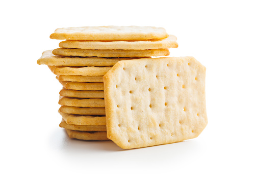 A pile of crackers stacked on a plain white surface. Isolated on white background.