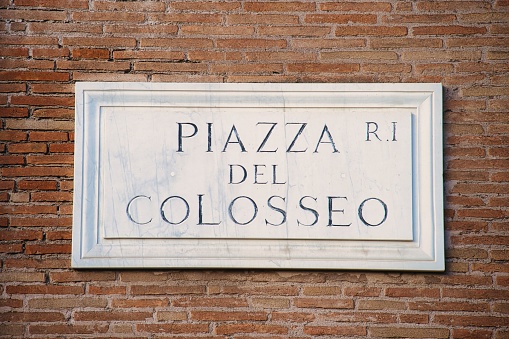 Piazza del Colosseo sign on a brick wall. Rome, Italy