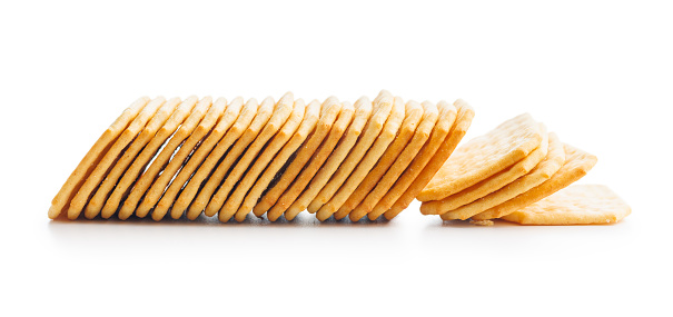 Crackers stacked on a plain white surface. Isolated on white background.