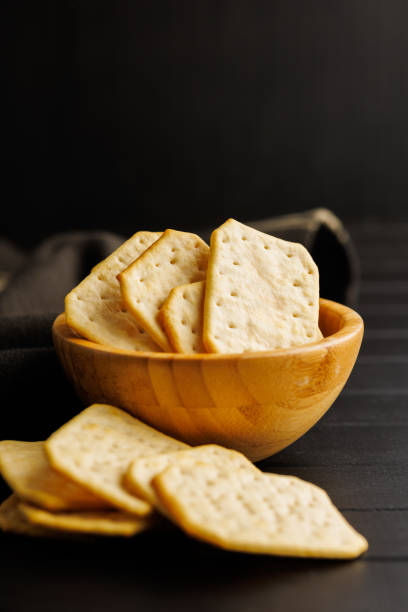 istock Salted Crackers in bowl Against a Dark Background 2096184952