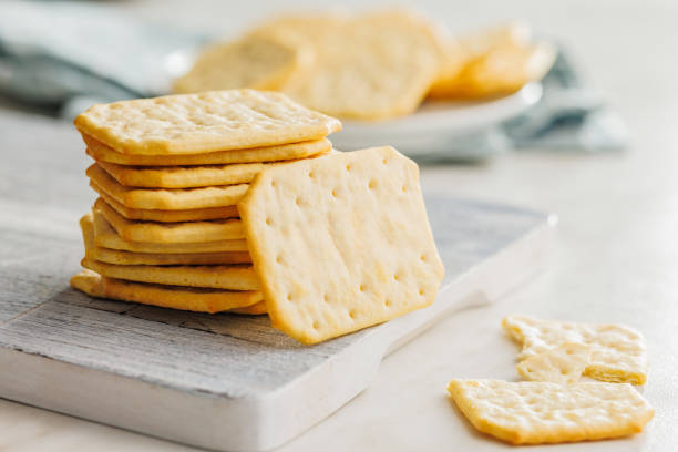 istock Golden Baked Crackers on cutting board on a White kitchen table. 2096185961