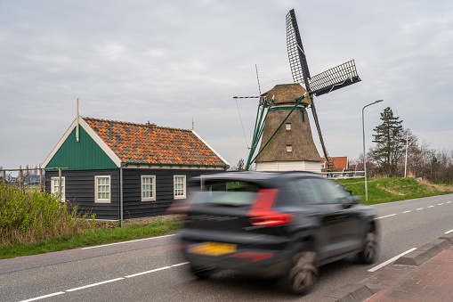 Akersloot, The Netherlands, 10.03.2024, Traffic on the motorway next historical dutch windmill De Oude Knegt in Akersloot