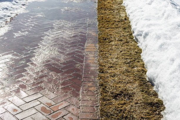 istock sidewalk in early spring when the snow melts. 2096207424