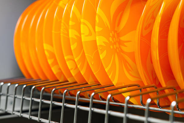 orange plates stand in the kitchen cabinet. plate in the dryer