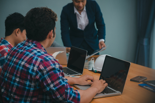 Collaborate between Professional Businesswoman and Partnership. Group of Business people discuss and point solution problem in brainstorming meeting. Man hand using laptop. Strategy Business concept.