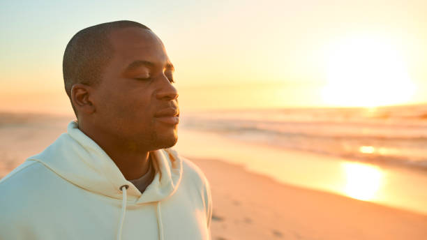 istock Casually Dressed Young Man With Closed Eyes On Beach With Beautiful Sunrise Over Sea 2096240407