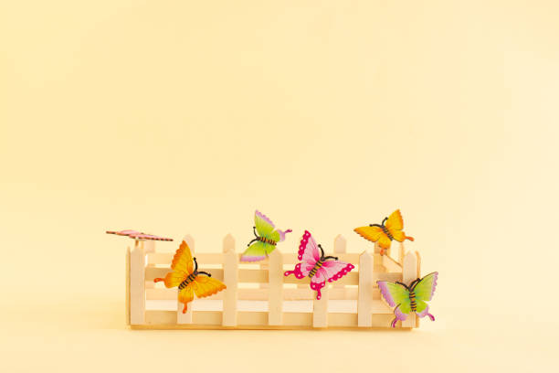 Easter basket with butterflies on a yellow background. Minimal decorative concept with copy space.