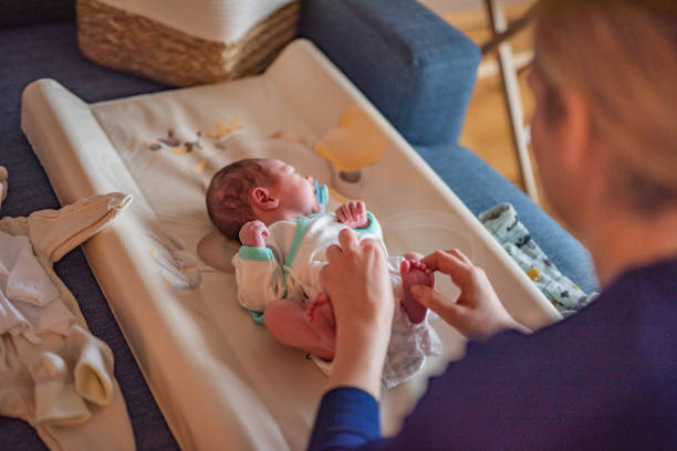 istock Mother is changing diaper to her little newborn baby boy. 2096242544