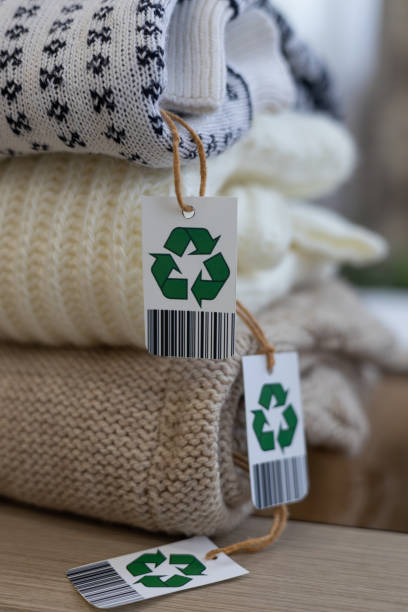 istock Close-up. A stack of clothes made from natural eco-friendly wool. Biodegradable, eco-friendly, natural clothing with a recycled label is folded into a neat stack. Eco-friendly clothing. 2096254682