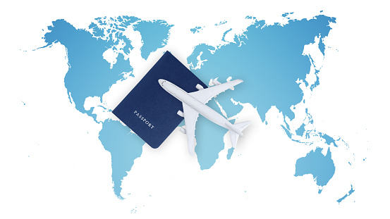 Top view of a passport with airplane and a stethoscope on world map background, medical insurance travel concept whether it's a summer beach vacation or a business trip. Health and safety