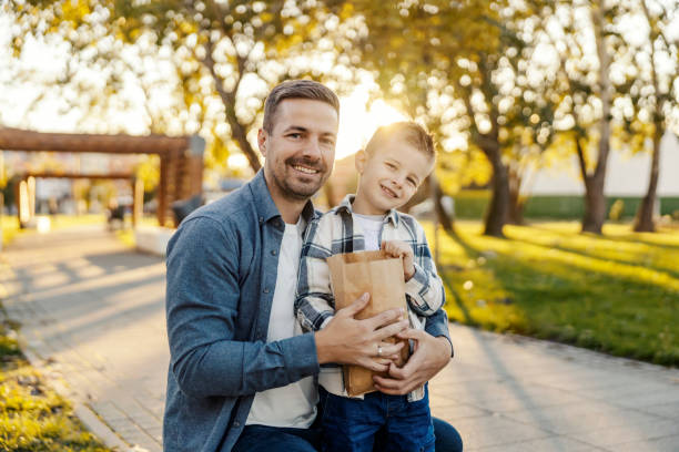 istock A cheerful father and son having fun in park and eating popcorn. 2096265781