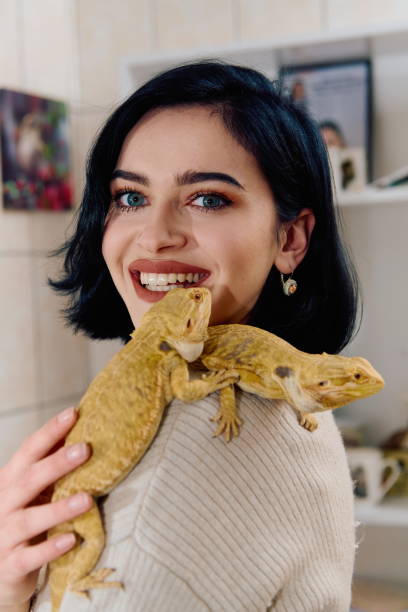 istock Beautiful Woman Posing with Her Two Adorable Bearded Dragon Pets 2096268392